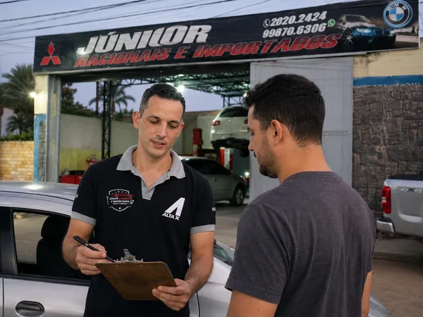 Consultor da Júnior conferindo o veículo do cliente na entrada da oficina